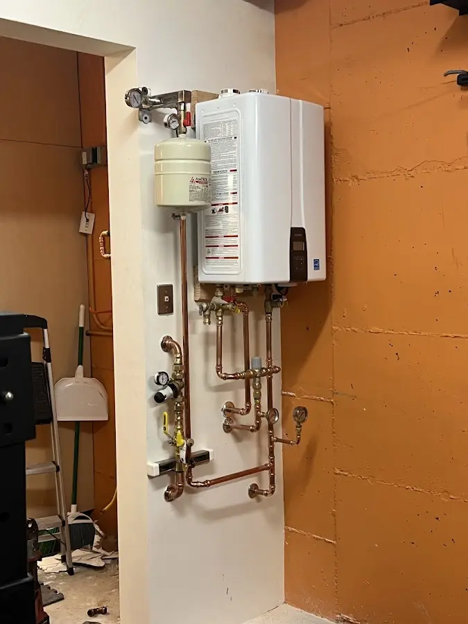 Plumbing technician inspecting water heater connections in Northumberland